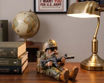 Funny military gnome statue, crafted with detailed camouflage gear and realistic features. A unique gift for veterans, gun lovers