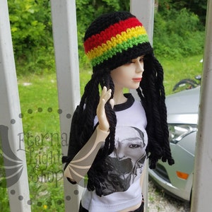 May include: A black crochet hat with a red, yellow, and green stripe. The hat has long black crocheted dreadlocks attached.