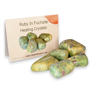 Peut inclure: Une collection de pierres polies et roulées de rubis sur fuchsite présentant des teintes vertes et jaunes marbrées avec de petites inclusions magenta. À côté se trouve une carte pliée avec l'inscription Ruby In Fuchsite Healing Crystals.