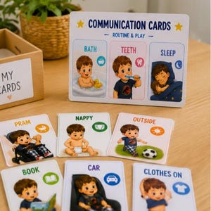 May include: A set of Communication Cards for routine and play, featuring a large instructional board and smaller individual cards. Each card displays a cartoon child performing daily activities like bathing, brushing teeth, sleeping, and playing.