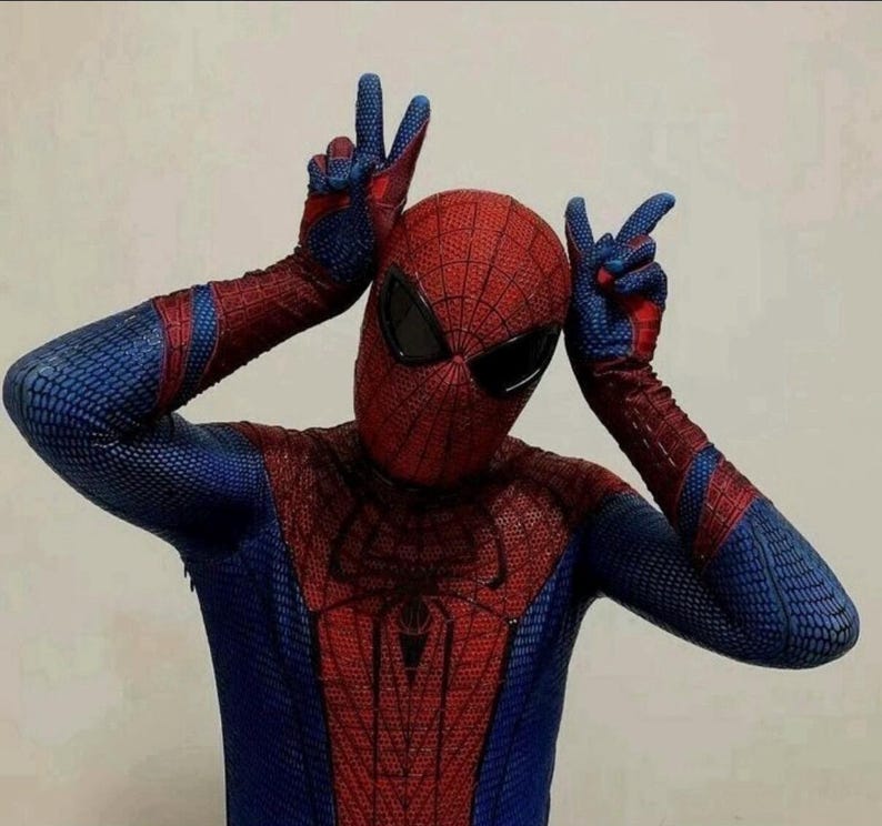 Puede incluir: Un disfraz de cuerpo completo de elastano con un esquema de color rojo y azul y un patr&oacute;n de red texturizado en toda la prenda. La m&aacute;scara incluye lentes oculares grandes, oscuros y angulares, con un emblema de ara&ntilde;a negro en el pecho.