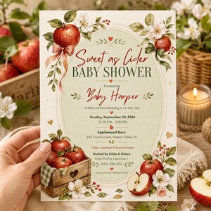 May include: A rectangular baby shower invitation card featuring a cream background with red apple and white blossom illustrations. The text reads Sweet as Cider Baby Shower, Honoring Baby Harper, Sunday, September 20, 2026, at Applewood Barn.