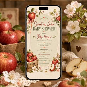May include: A smartphone displaying a digital baby shower invitation with a cream background, red apple illustrations, and floral accents. The text reads Sweet as Cider BABY SHOWER, Honoring Baby Harper, Sunday, September 20, 2026, 12:30 PM - 3:30 PM, Applewood Barn, 245 Country Lane, Hudson Valley, NY, cider, pastries & brunch bites, Hosted by Emily & Grace, RSVP by September 1, (555) 208-4178.