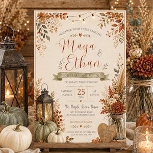 May include: A wedding invitation card featuring a cream background with autumn-themed illustrations of dried leaves, pumpkins, and lanterns. The text includes the names Maya and Ethan, the date October 25, 2026, and the location The Maple Grove Barn.