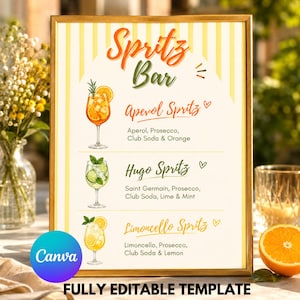Könnte beinhalten: Ein rechteckiges Schild in einem goldenen Rahmen mit gelb-weiß gestreiftem Hintergrund. Der Text lautet Spritz Bar, Aperol Spritz, Hugo Spritz und Limoncello Spritz, ergänzt durch Illustrationen von drei Cocktails und deren Zutaten.