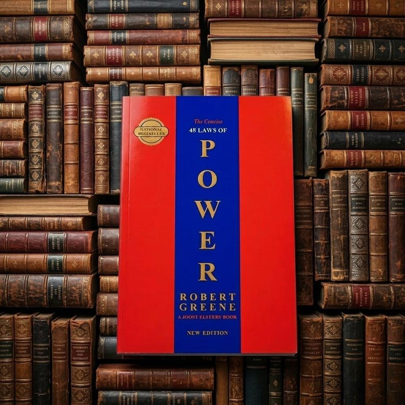 Pu&ograve; includere: Un libro intitolato The Concise 48 Laws of Power di Robert Greene con una copertina rosso brillante e una striscia blu verticale centrale. Il titolo &egrave; in oro e un sigillo dorato National Bestseller &egrave; visibile in alto a sinistra sulla copertina.