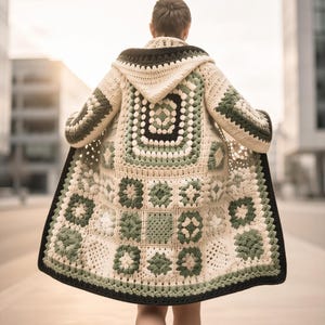May include: A long-sleeved hooded cardigan made from crocheted granny squares in shades of cream, sage green, and dark brown. The garment features a large central square pattern on the back, long sleeves, and a dark brown border along the edges.