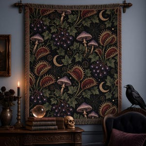May include: A rectangular woven wall tapestry featuring a dark botanical pattern of purple mushrooms, red and green Venus flytraps, dark berries, green ivy leaves, spiderwebs, and golden crescent moons on a black background with fringed edges.