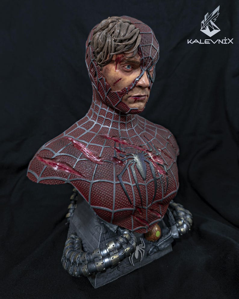 May include: A detailed bust of a character wearing a damaged red and black spider-web patterned suit with exposed human skin and hair on one side. The chest features a spider emblem and deep gashes. Metallic mechanical tentacles wrap around the base.