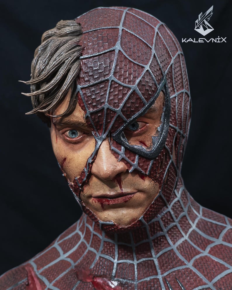 May include: A detailed bust sculpture of a human face partially covered by a red and silver spider-web patterned mask. The exposed skin shows realistic textures, blue eyes, and brown hair. The text KALEVNIX is printed in the upper right corner.