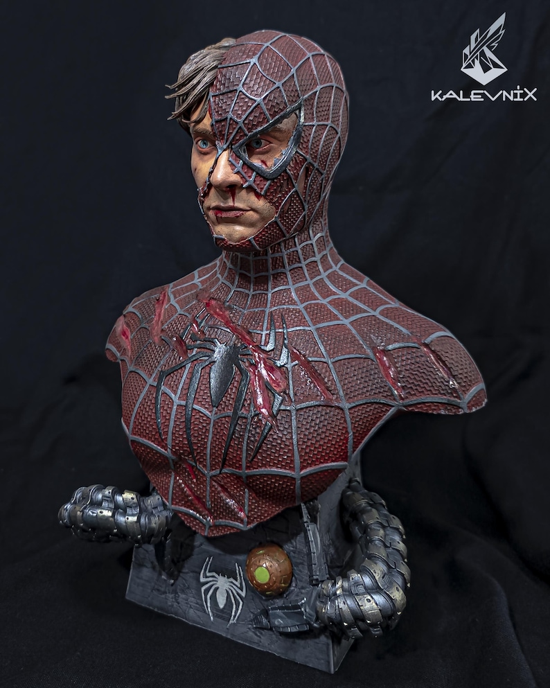 May include: A detailed bust of a character with a half-exposed human face and a half-masked red and black spider-patterned suit. The chest features battle damage, and the base includes mechanical tentacles and the text KALEVNIX in the corner.