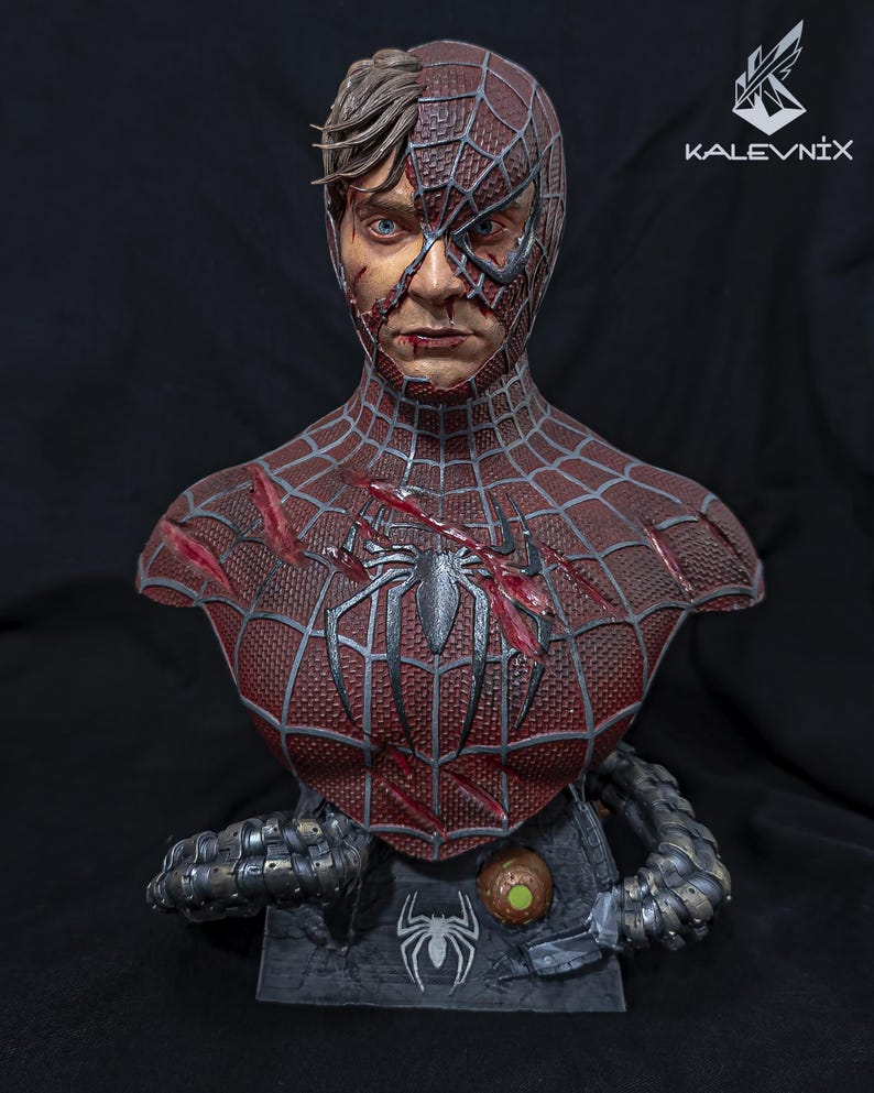 May include: A detailed bust of a character with a half-exposed human face and a half-masked spider-themed suit. The suit is dark red with a black web pattern, battle damage, and a central spider emblem. Metallic mechanical tentacles wrap around the base.