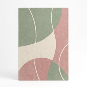 May include: A rectangular area rug featuring a textured surface with abstract, curved shapes in muted sage green, dusty rose pink, and cream. The design is defined by thin, flowing white lines that separate the distinct color-blocked sections.