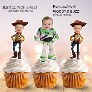 May include: Three cupcake toppers on a 21.59 x 27.94 cm sheet featuring personalised Woody and Buzz characters with a baby's face. The toppers show a cowboy outfit with a brown hat and a space ranger suit with green, white, and purple armour.