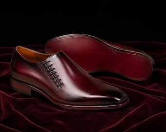 Sapatos sociais masculinos Oxblood com cadarço lateral, feitos à mão em couro de bezerro, com sola vermelha exclusiva.