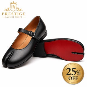 May include: A pair of black leather split-toe Mary Jane shoes with a buckle strap and a bright red sole. The shoes feature a distinct cleft design at the toe area. The brand logo Prestige Haus of Craft is visible at the top left corner of the image.