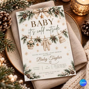 Op de afbeelding: Een rechthoekige uitnodigingskaart voor een babyshower met de tekst BABY it's cold outside, een waslijn met een teddybeer, een rompertje en een mutsje, versierd met dennentakken, dennenappels, gouden sterren en sneeuwvlokken.