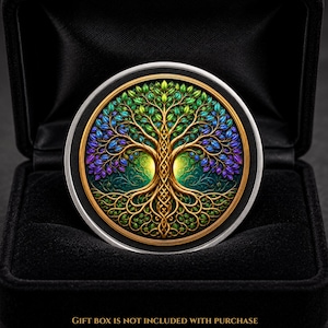 May include: A circular medallion featuring a detailed golden tree of life with intricate roots and branches adorned with vibrant green, blue, and purple leaves, set against a dark background, presented in a black case with the text GIFT BOX IS NOT INCLUDED WITH PURCHASE.