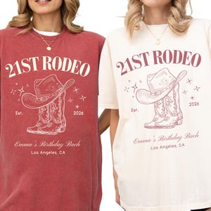 May include: Two short-sleeve t-shirts, one crimson with an ivory graphic and one ivory with a crimson graphic. Both feature the text 21ST RODEO, Est. 2026, Emma's Birthday Bach, Los Angeles, CA, and an illustration of a cowboy hat and boots.