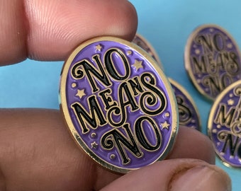 May include: Purple enamel pin with gold trim featuring the text "NO MEANS NO" in black lettering with stars around the text.