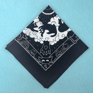 Puede incluir: Bandana negra con un dise&ntilde;o blanco de gatos y nubes. Los gatos est&aacute;n en varias poses, incluyendo dormir, jugar y mirar hacia arriba a las nubes. La bandana est&aacute; hecha de algod&oacute;n y mide aproximadamente 56 cm cuadrados.