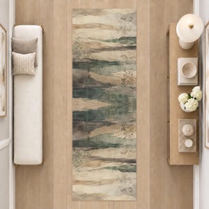 May include: A rectangular area rug featuring a horizontal abstract landscape pattern in muted shades of sage green, charcoal gray, and beige. The design includes subtle, delicate line drawings of botanical stems and foliage scattered across the surface.