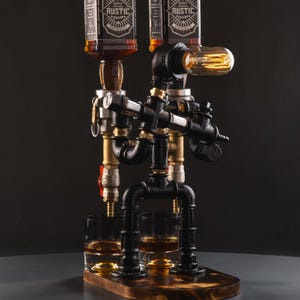 May include: A liquor dispenser constructed from black industrial iron pipes and brass fittings, featuring two inverted bottles labeled RUSTIC Design. The structure includes a glowing Edison bulb and two glass tumblers on a dark wooden base.