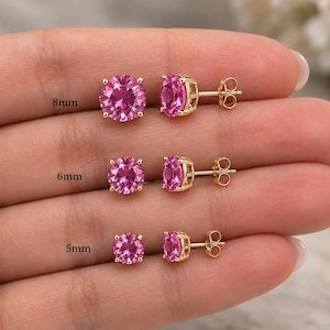 May include: Three pairs of round-cut pink gemstone stud earrings set in gold metal prongs with butterfly backings. The earrings are labeled with sizes 8mm, 6mm, and 5mm, showing the varying diameters of the stones in a clear, side-by-side comparison.