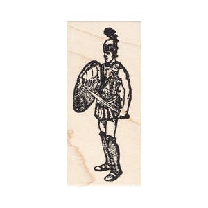 May include: A black and white illustration of a Roman soldier, complete with helmet, shield, and sword, is stamped on a wooden block. The soldier is depicted in a standing pose, ready for battle. The stamp is ideal for crafting or historical projects.