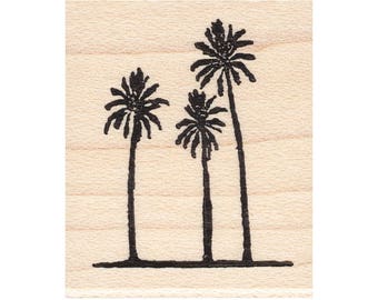 May include: A wood-mounted rubber stamp with a design of three palm trees in black ink.