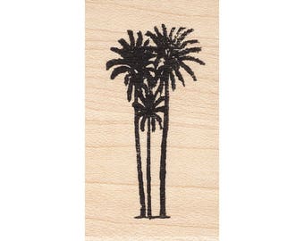May include: A black palm tree stamp on a light wood block. The stamp features three palm trees with detailed fronds and long, slender trunks. The design is simple and suitable for various crafting projects.