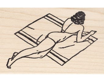 以下が含まれることがあります： ビーチタオルに横たわる人の白黒線画。 後ろから見た人で、髪はカールにスタイリングされています。 タオルには黒いストライプがあり、明るい木材の表面に置かれています。