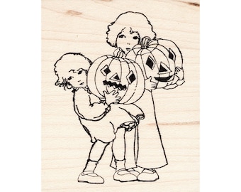 May include: Two children in vintage clothing are holding carved pumpkins. The girl on the left is wearing a dress and the girl on the right is wearing a long dress. Both pumpkins have carved faces.