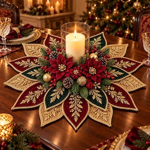 May include: A circular Christmas centerpiece featuring a central white pillar candle in a glass cylinder, surrounded by layered fabric petals in deep red, dark green, and gold, accented with pine cones, red berries, and gold ornaments.