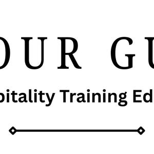 May include: A white rectangular sign featuring the black text BE OUR GUEST in a large serif font, followed by the smaller sans-serif text Hospitality Training Edition, and a thin horizontal line with diamond-shaped ends at the bottom.