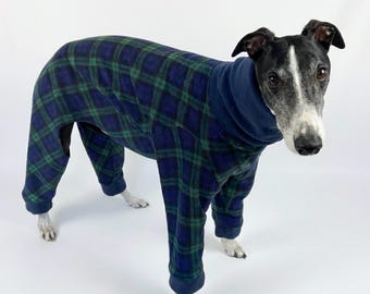 May include: A dog wearing a full-body fleece jumpsuit featuring a dark blue and green plaid pattern. The garment includes a high turtleneck collar and long sleeves that cover the legs, providing full coverage for the animal's torso and limbs.