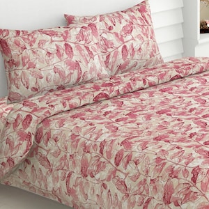May include: A bedding set featuring a cream-colored base with a repeating pattern of dark pink leaves and branches. The set includes a duvet cover and two matching pillowcases, all displaying the same botanical print across the fabric surface.