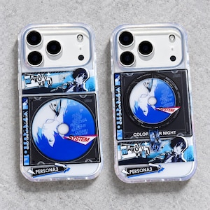 May include: Two clear smartphone cases featuring Persona 3 graphics. Each case displays a blue and black compact disc design with the text SYSTEM, Persona 3, and Makoto Yuki. The designs include anime-style character illustrations and geometric patterns.