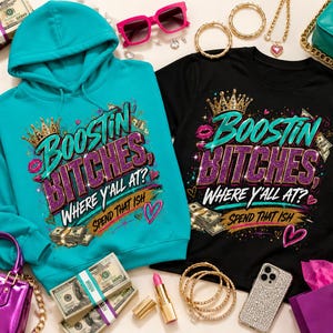 Może przedstawiać: Turkusowa bluza z kapturem i czarny t-shirt, oba z nadrukiem graficznym przedstawiającym złotą koronę, fioletowy brokatowy napis BOOSTIN BITCHES, WHERE Y'ALL AT? oraz SPEND THAT ISH, ozdobione różowymi ustami, sercami i plikami banknotów.