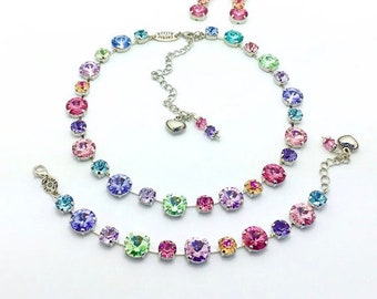 May include: A rainbow crystal necklace and bracelet set with silver chain and heart charm. The necklace and bracelet feature round, multi-coloured crystals.