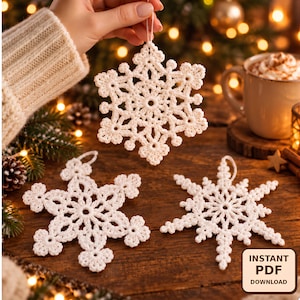 May include: Three white crocheted snowflake ornaments with intricate lace-like patterns and loops for hanging. The ornaments feature six-pointed designs with delicate stitching. A small square graphic in the corner displays the text INSTANT PDF DOWNLOAD.