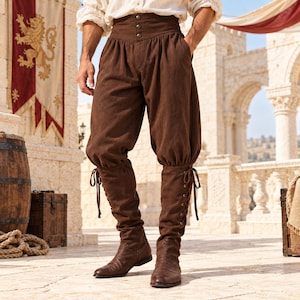 Puede incluir: Pantalones de talle alto en color marrón oscuro con una cintura ancha de tres botones y un diseño de pierna holgada y fruncida. Los pantalones se combinan con botas a juego hasta la rodilla que presentan cordones laterales atados.