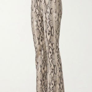 May include: High-waisted trousers featuring a full-length snakeskin print in shades of beige, tan, and dark brown. These pants have a straight-leg cut, a structured waistband with belt loops, a front zipper fly, and a visible horizontal seam.