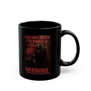 May include: A black ceramic mug featuring a graphic print of a hooded skeleton holding a rifle, accompanied by three dogs. The text reads 2ND BATTALION 7TH MARINES, WARDOGS, and the quote CRY HAVOC AND LET SLIP THE DOGS OF WAR in red lettering.