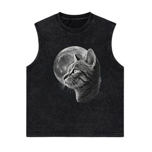 May include: A black sleeveless shirt with a mineral wash finish featuring a detailed graphic print of a cat in profile looking toward a large, textured full moon. The design is rendered in shades of gray and white against the dark fabric.