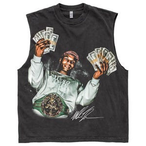 May include: A charcoal grey sleeveless t-shirt featuring a graphic print of Mike Tyson wearing a light grey sweatshirt, a red patterned cap, and a green championship belt. The figure holds stacks of cash in both hands, with a signature below.