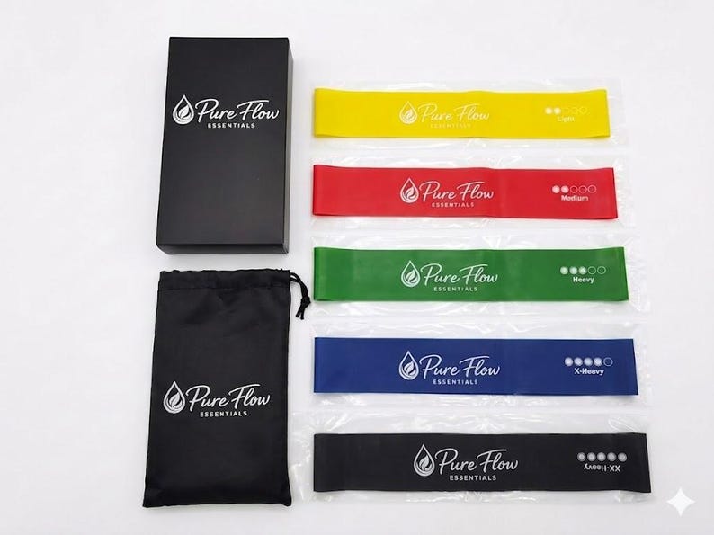 May include: A set of five resistance bands in yellow, red, green, blue, and black, each labeled Pure Flow Essentials with varying resistance levels. Includes a black storage bag and a black rectangular box, both featuring the Pure Flow Essentials logo.