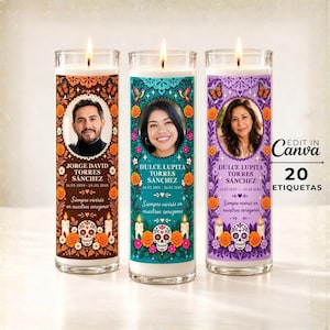 May include: Three cylindrical glass prayer candles featuring colorful floral patterns, butterflies, and sugar skull illustrations. Each candle displays a portrait of a person, a name, dates, and the text "Siempre vivirás en nuestros corazones."