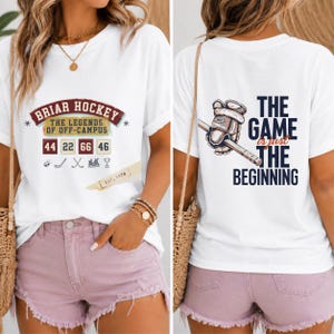 Könnte beinhalten: Ein weißes Kurzarm-T-Shirt mit einem Frontaufdruck mit dem Text BRIAR HOCKEY THE LEGENDS OF OFF-CAMPUS, den Zahlen 44 22 66 46 und Eishockey-Symbolen. Die Rückseite zeigt einen Eishockeyhandschuh mit Schläger und den Text THE GAME is just THE BEGINNING.