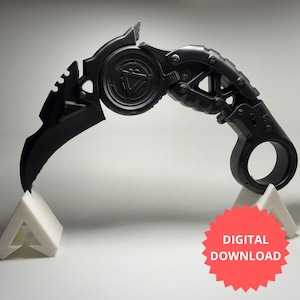 May include: A matte black curved karambit-style blade featuring a circular finger ring at the handle, a central mechanical gear-like pivot point with a triangular emblem, and a serrated spine. A red starburst graphic reads DIGITAL DOWNLOAD.